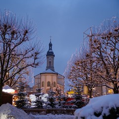 Eine kleine Kirche und Bäume im Schnee.