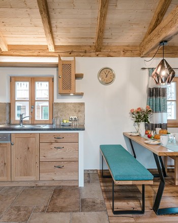 Wohnbereich im Chalet mit Küche, Essbereich und Fernseher.