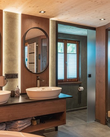 Badezimmer mit zwei Waschbecken und eigener Sauna.