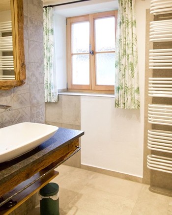 Waschbecken, Spiegel und Handtuchablage im Badezimmer der Ferienwohnung.