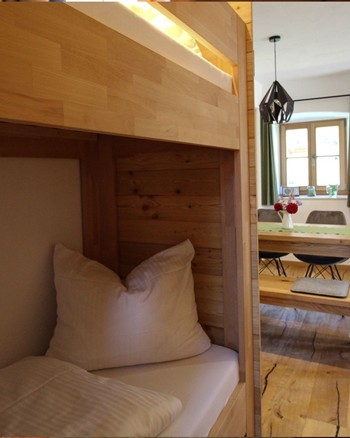 Stockbett in einem schmalen Gang der zur Küche hin öffnet.