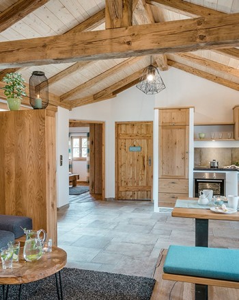 Wohnraum im Chalet mit Küche, Esstisch und Couch.