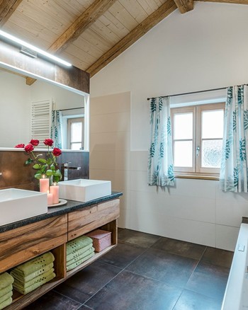 Badezimmer mit Badewanne, zwei Waschbecken und Spiegel.