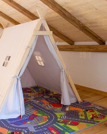 Ein Zelt auf einem Teppich mit Straßen & Gebäuden darauf.