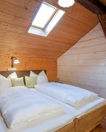 Schlafzimmer mit Doppelbett und Verbindungstür zu einem weiteren Schlafzimmer.