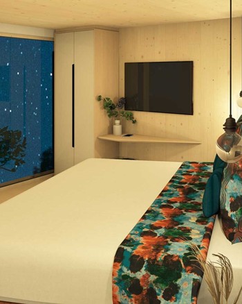 Schlafzimmer mit Doppelbett und freistehender Badewanne vor einem großen Fenster.