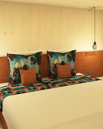 Schlafzimmer mit Doppelbett und orangen und blauen Farbakzenten.