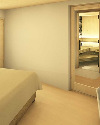 Schlafzimmer mit Doppelbett und freistehender Badewanne vor einem großen Fenster.