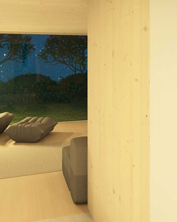 Blick durch einen Torbogen ins Wohnzimmer mit Sessel und Fensterfront in den Garten.