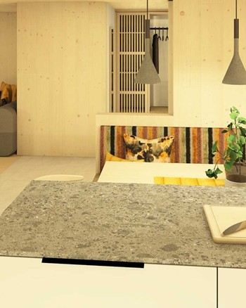 Kücheninsel und Esstisch mit Sitzbank und Blick zum Sofa im Wohnzimmer.