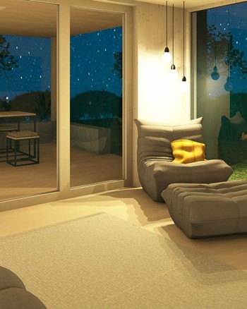 Gemütlicher Sessel im Wohnzimmer mit Fensterfronten zur Terrasse und zum Garten auf beiden Seiten.