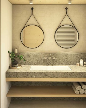 Badezimmer mit Dusche, Waschbecken und zwei Spiegeln.