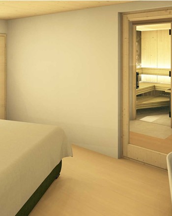 Schlafzimmer mit Doppelbett und freistehender Badewanne vor einem großen Fenster.