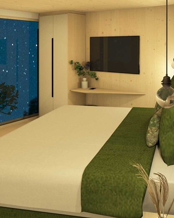 Schlafzimmer mit Doppelbett und freistehender Badewanne vor einem großen Fenster.