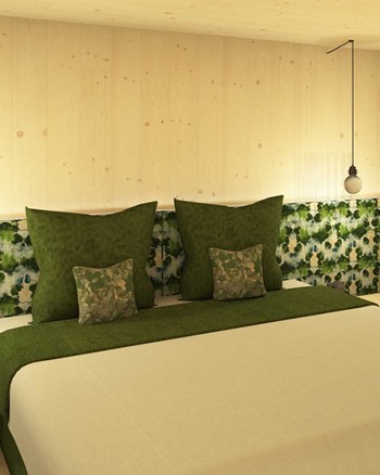 Schlafzimmer mit Doppelbett und grünen Farbakzenten.