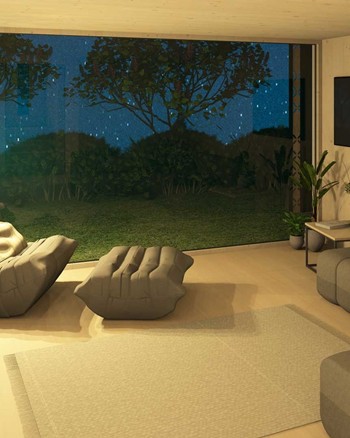 Wohnzimmer mit Sofa, Sessel, Fernseher und Fensterfront zum Garten.