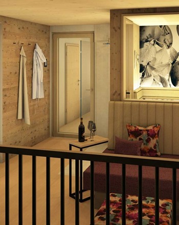 Ein Balkon mit einer Sitzbank und einem Beistelltisch mit einer Flasche Wein und zwei Gläsern. 