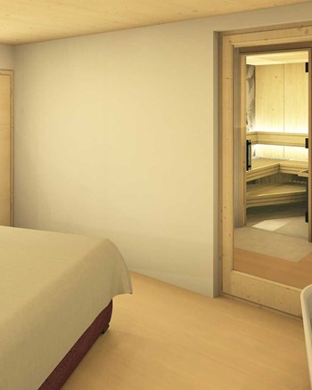 Schlafzimmer mit Doppelbett und freistehender Badewanne vor einem großen Fenster.