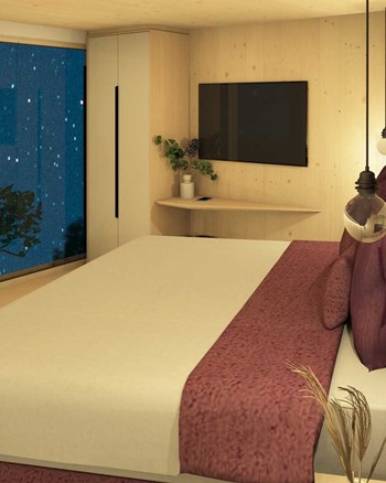 Schlafzimmer mit Doppelbett und freistehender Badewanne vor einem großen Fenster.