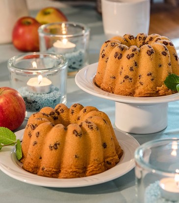 Zwei Gugelhupf-Kuchen auf einem Tisch drapiert.