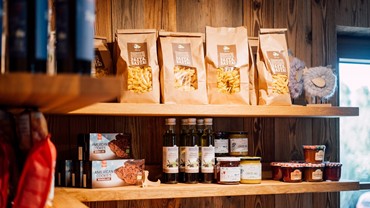 Regale mit Pasta, Keksen, Olivenöl und Honig im Hofladen.