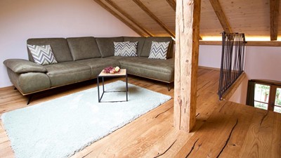 Großes Sofa im Wohnzimmer mit Dachschräge.