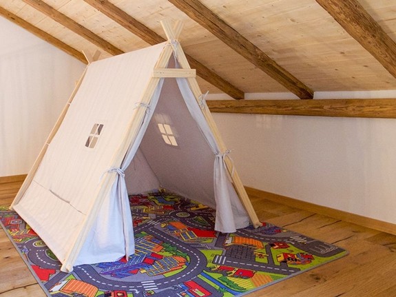 Ein Zelt auf einem Teppich mit Straßen & Gebäuden darauf.