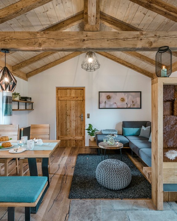 Wohn-Essbereich im Chalet mit Tisch, Stühlen und Sofa.