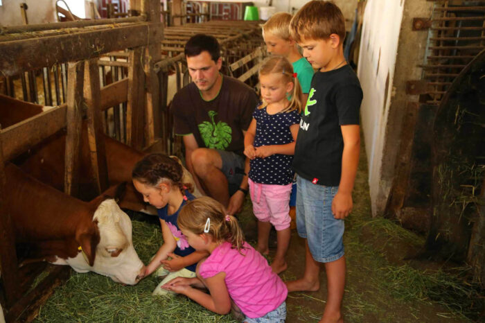Kinder mit Bauer Michi im Stall, Huberhof Ollerding